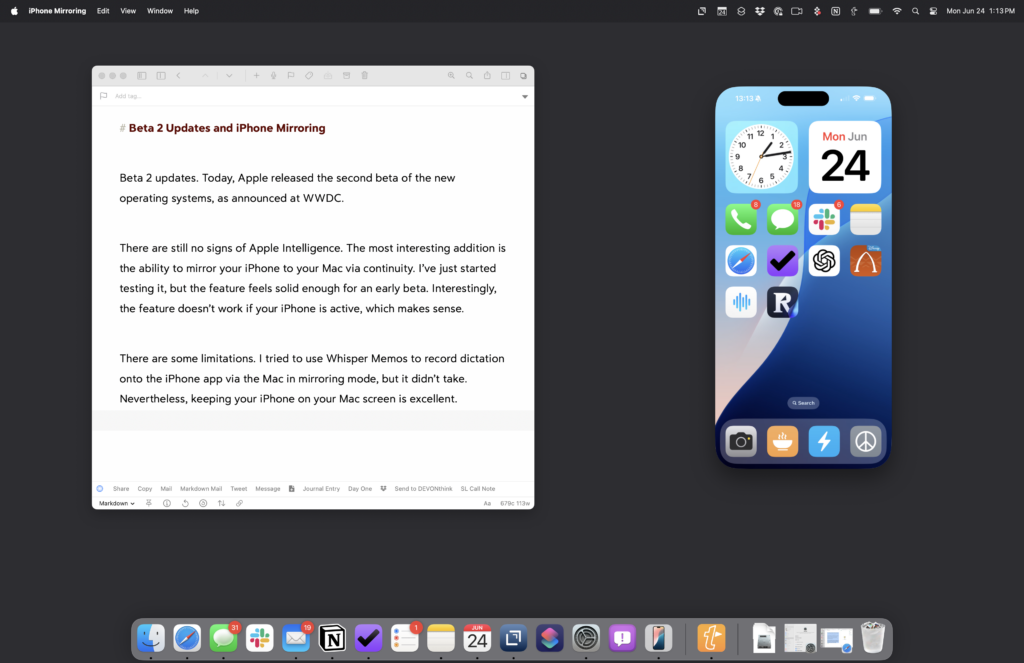 A Mac desktop with a gray background showing a Drafts window on the left side, and an iPhone visible using the new iPhone mirroring app available in the beta two version of macOS Sonoma. 