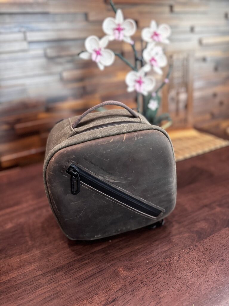 closed waterfield shield case in brown, for vision pro. it is on a dark wood desk.